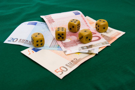 euro money  and stack dice on green backgroundの写真素材