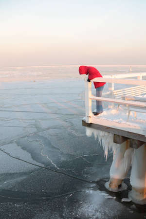 Women in red. Pier, jetty  on the sea - ice - floe. Poland, Gdyniaの写真素材