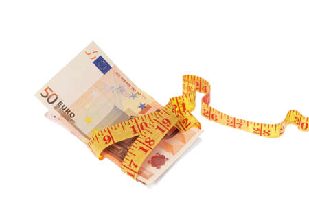 Measuring tape wrapped around the roll of euro banknotes の写真素材