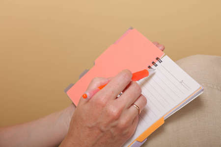 Notebook and a red pen in the hands of women の写真素材