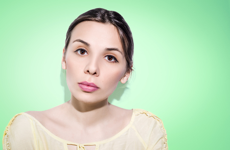 Woman with folded hair on green background. Nude make-up.の写真素材