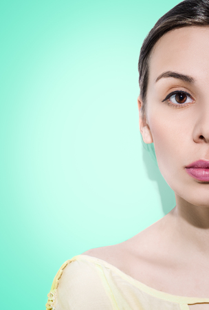 Half-faced woman on green background. Concentrated face.の写真素材