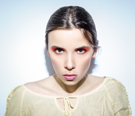 A portrait of woman on blue background. Light colors combine with bright eyeshadows.の写真素材