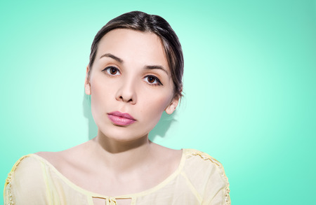 Woman with folded hair on bright green background. Nude make-up.の写真素材