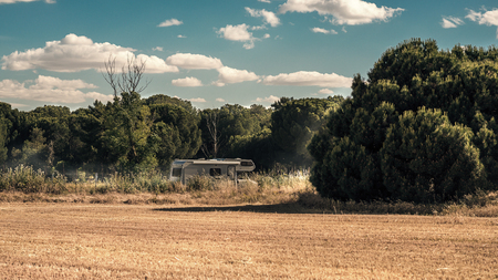 van riding through the field.  trees and clouds of dustの写真素材