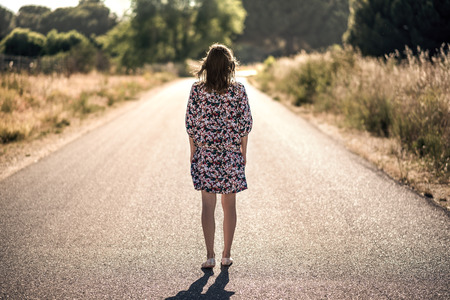 bright dreesed girl on the way. the empty roadの写真素材
