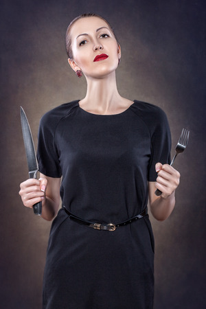 Girl with red lips with a fork and knife の写真素材