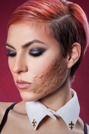 Close-up portrait of a girl with glitter on her cheek and expressive makeup の写真素材