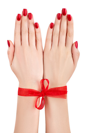 Beautiful female hands tied red ribbon の写真素材