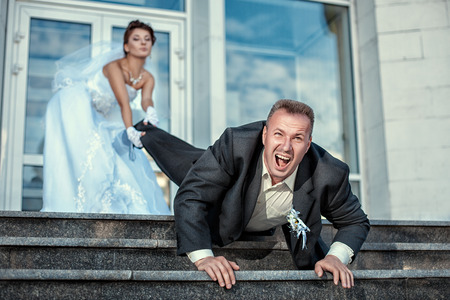 Bride leg pulls groom at the wedding の写真素材