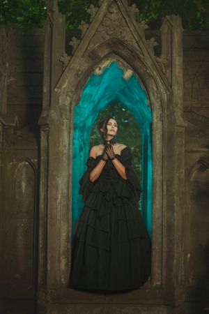 Girl in the window of the castle stands the night in the Gothic manner.の写真素材