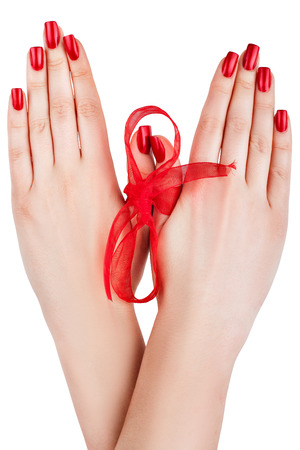 Beautiful female hands tied a red ribbon.の写真素材