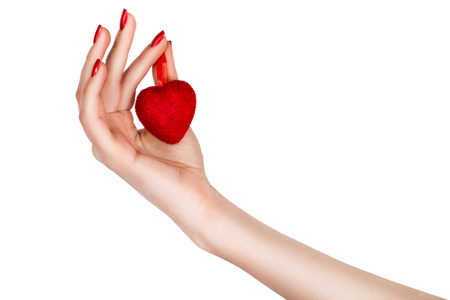 Female hand holding a heart on a white background.の写真素材