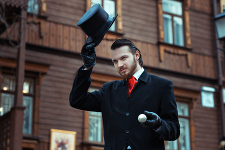 Man in retro style is on the street in his hand headdress cylinder.の写真素材