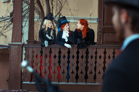 Girls in retro style discussing man who looks at them.の写真素材