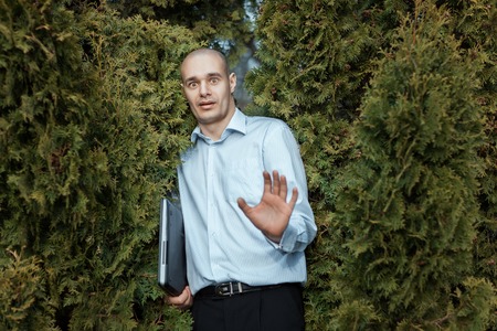 Man bald head and the frightened face. Under his arm he is holding a laptop.の写真素材