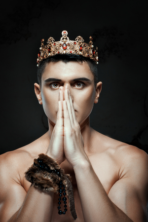 Man with a crown on his head to pray with folded hands.の写真素材