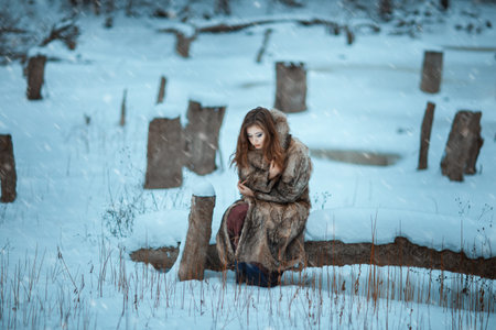 Girl froze in the winter woods. Around covered with snow and it is cold.
