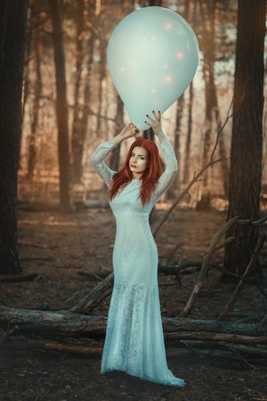 Woman in fairy forest with a huge inflatable ball.の写真素材