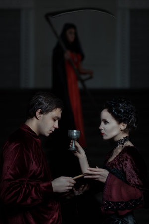 Man is holding a book, and the woman with the cup, is death on the background.の写真素材