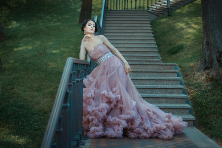 Girl flirting on her wearing a long luxuriant dress with a train.の写真素材
