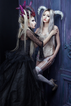 Two women in gothic outfits, their hair on the head with horns.の写真素材