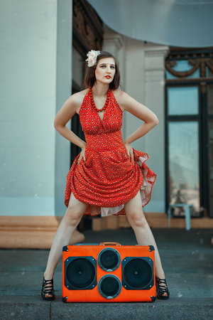 Woman dancing near the musical installation, retro style.の写真素材