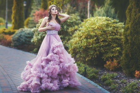 Woman in a beautiful dress walks in the park, wears a crown on his head.の写真素材