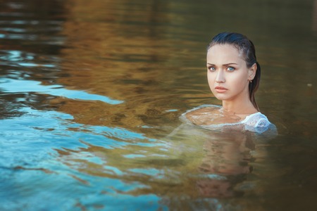 Portrait of a woman in the water, she in a dress and all wet.の写真素材