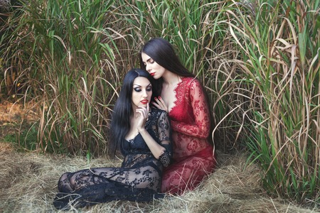 Two women flirting in nature, they are dressed in negligees.の写真素材