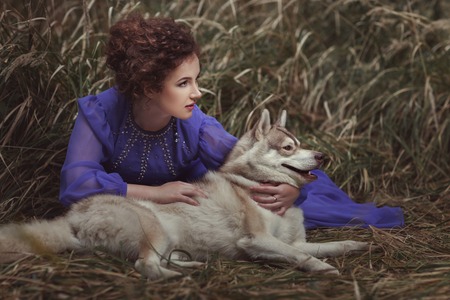 Woman with dog closely watching to the side.の写真素材