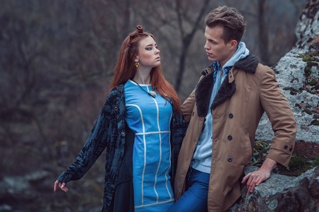 Guy with the girl look at each other, they in the wood among rocks.の写真素材