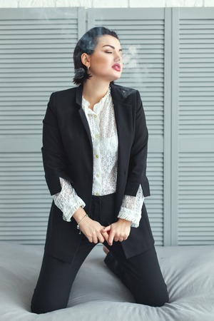 Woman flirting on the bed, she was sexy and exhales smoke.の写真素材