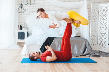 Family morning exercises in the bedroom near the bed.の写真素材