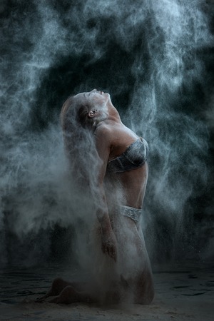 Artistic performance, a girl in a cloud of dust from flour.の写真素材