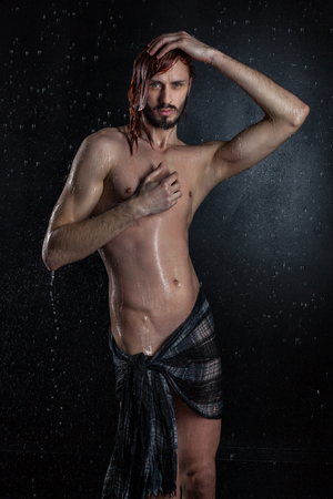 Erotic naked and wet man, he has feminine manners.の写真素材