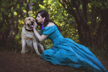 Woman is talking to a big dog, they are in the forest.の写真素材