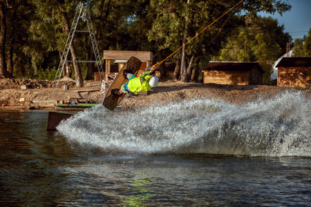 Summer sport wakeboarding. Skating and jumping on the water on the board.の写真素材