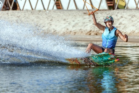 Woman is an extreme sportswoman on a wakeboard on the water.の写真素材