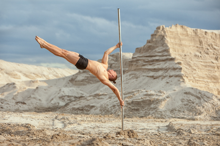 Man shows acrobatic stunts on the pole.の写真素材