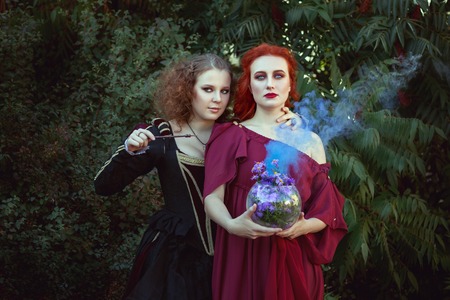 Two women are engaged in witchcraft, they are shamans and make spells.の写真素材