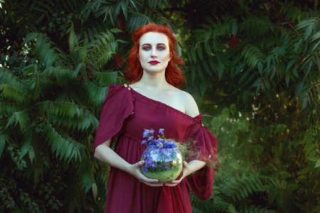 Beautiful woman is a shaman, in her hands she is holding magic.の写真素材