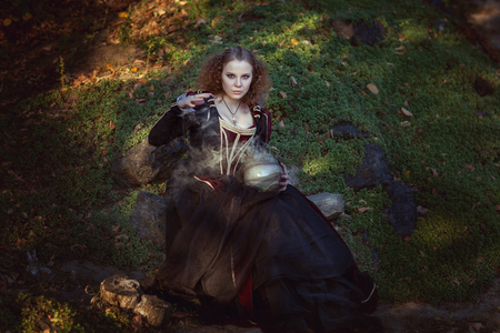 Woman is engaged in magic, she cooks a magic potion.の写真素材