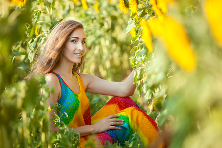 Lovely woman among yellow sunflowers in the field.の写真素材
