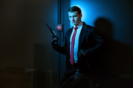 Man with a profession is a murderer, in his hand a pistol with a silencer.の写真素材
