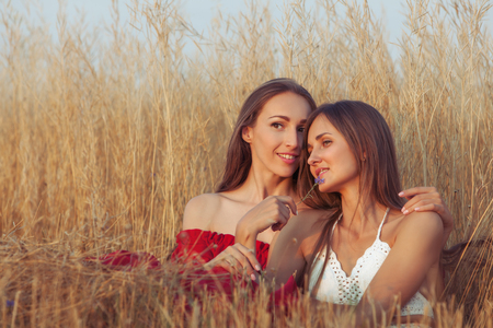 Women sit embracing, they are in love and flirting.の写真素材