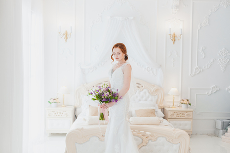 Bride with a bouquet of flowers in the bedroom.の写真素材