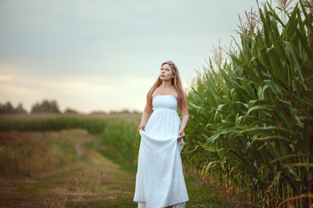 Woman in a white dress is walking around the village.の写真素材