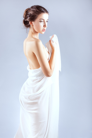 Beautiful girl wrapped in a white sheet.の写真素材