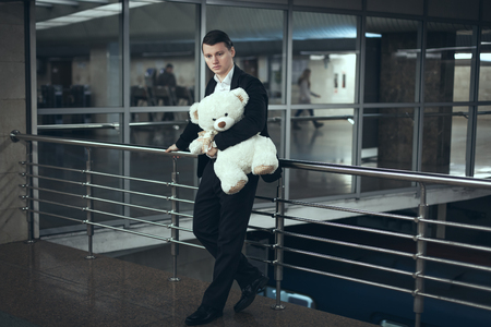 Sad man with a teddy bear in his hands awaiting a meeting.の写真素材